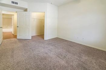 a bedroom with an open door and a carpeted floor
